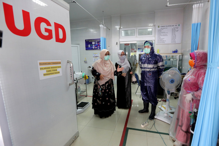 Ketua Komisi IV DPRK Banda Aceh Tati Meutia Asmara (kiri) berbincang dengan petugas medis Puskesmas Meuraxa yang memakai jas hujan plastik sebagai Alat Pelindung Diri (APD) untuk melayani pasien di Banda Aceh, Aceh. 