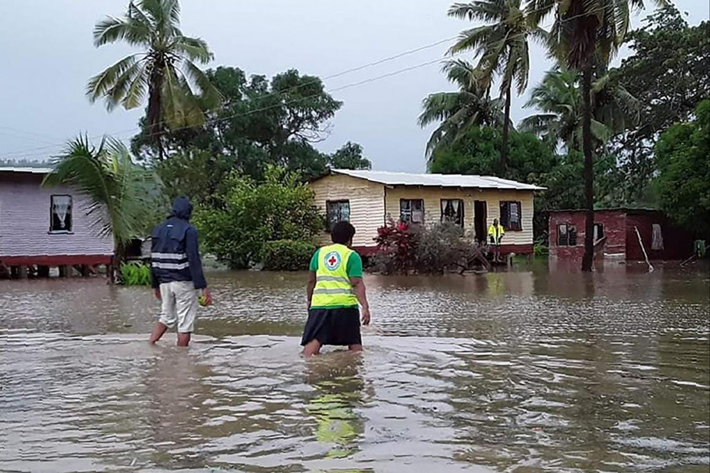 Petugas penyelamat melewati desa saat banjir yang disebabkan oleh topan tropis Harold di Nasolo di Fiji. AFP Photo/HO/International Federation of Red
