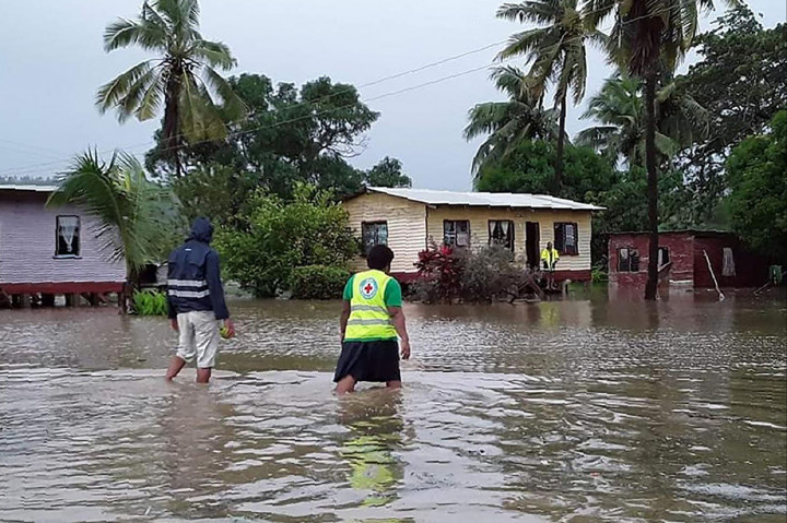 Petugas penyelamat melewati desa saat banjir yang disebabkan oleh topan tropis Harold di Nasolo di Fiji. AFP Photo/HO/International Federation of Red
