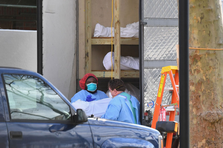 Petugas medis mengangkut jenazah dari sebuah truk berpendingin untuk dipindahkan ke Kingsbrook Jewish Medical Center, di Brooklyn, New York, Rabu, 8 April 2020.