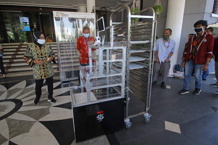 Wali Kota Surabaya Tri Rismaharini (kiri) melihat cara kerja Robot Service karya mahasiswa dan dosen Institut Teknologi (IT) Telkom Surabaya saat diuji coba di Balai Kota Surabaya, Jawa Timur.