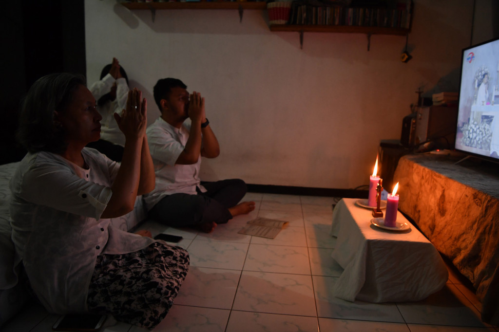 Umat Katolik mengikuti Misa Kamis Putih melalui media daring di rumahnya di Surabaya, Jawa Timur.