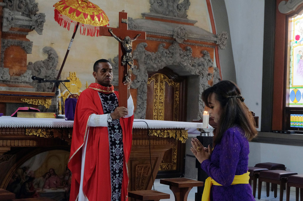 Umat Katolik melakukan kebaktian pada Misa Jumat Agung di Gereja Katolik Roh Kudus Paroki Babakan, Badung, Bali. Misa Jumat Agung di gereja tersebut hanya terbatas untuk beberapa umat yang hadir, sementara sebagian besar mengikuti melalui media daring dari rumah masing-masing. ANTARA FOTO/Nyoman Hendra Wibowo