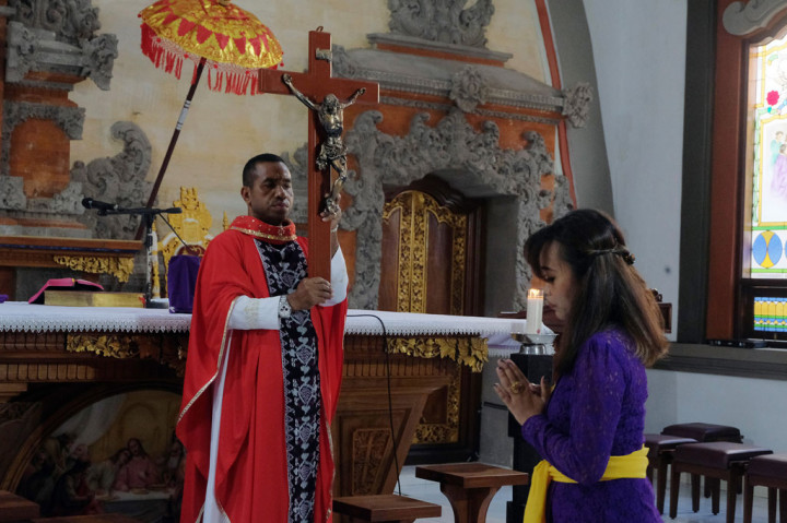 Umat Katolik melakukan kebaktian pada Misa Jumat Agung di Gereja Katolik Roh Kudus Paroki Babakan, Badung, Bali. Misa Jumat Agung di gereja tersebut hanya terbatas untuk beberapa umat yang hadir, sementara sebagian besar mengikuti melalui media daring dari rumah masing-masing. ANTARA FOTO/Nyoman Hendra Wibowo