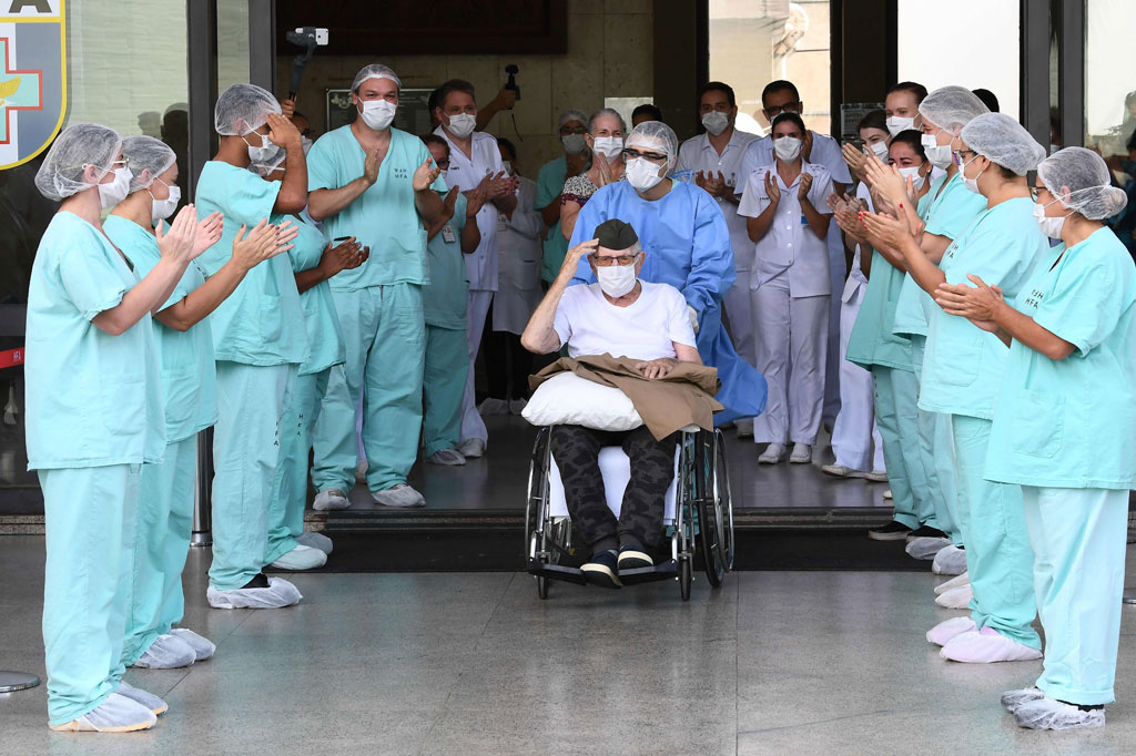 Veteran Perang Dunia II Ermando Piveta keluar dari RS Angkatan Bersenjata di Brasilia dengan sambutan tepuk tangan dari para petugas medis, usai dinyatakan sembuh dari virus korona (covid-19), Selasa, 14 April 2020 waktu setempat.