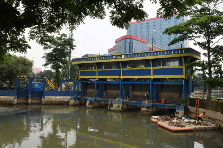 Petugas Penanganan Prasarana dan Sarana Umum (PPSU) membersihkan sampah yang berada di Pintu Air jembatan Merah, Jakarta.