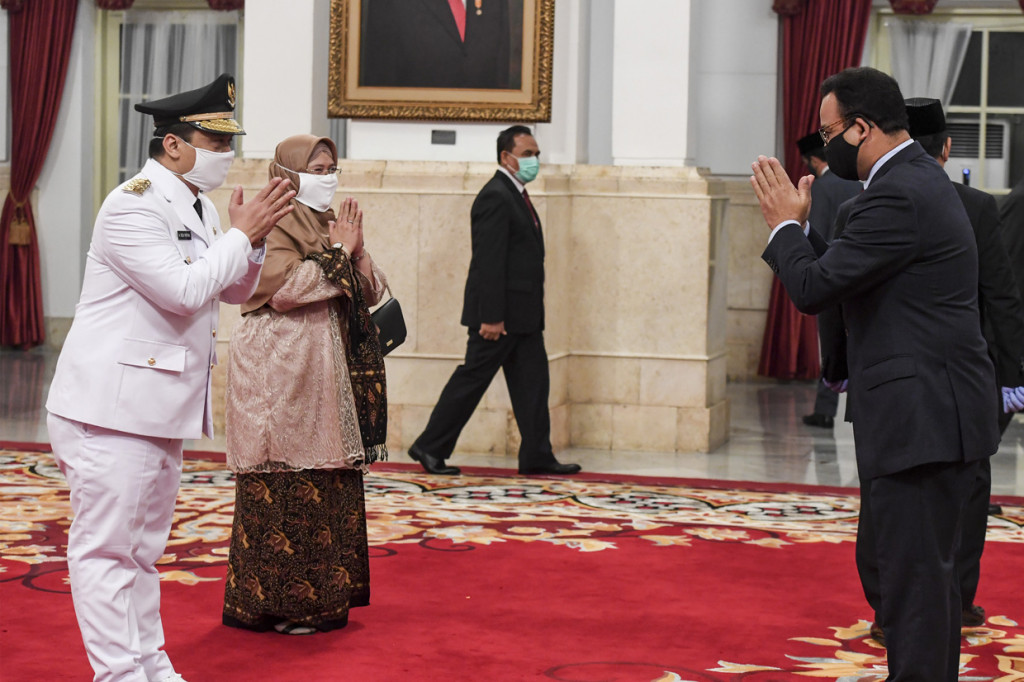 Gubernur DKI Jakarta Anies Baswedan (kanan) memberi ucapan selamat kepada Wakil Gubernur DKI Jakarta Ahmad Riza Patria seusai dilantik di Istana Negara, Jakarta.