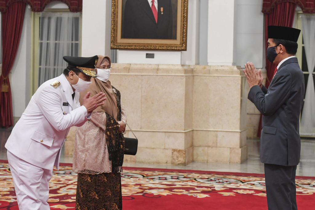 Presiden Joko Widodo (kanan) mengucapkan selamat kepada Wakil Gubernur DKI Jakarta Ahmad Riza Patria (kiri) seusai dilantik di Istana Negara, Jakarta.

