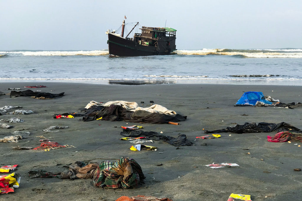 Pakaian milik warga Rohingya berserakan setelah perahu yang membawa mereka ditarik ke pantai di Teknaf, Bangladesh, Kamis, 16 April 2020.