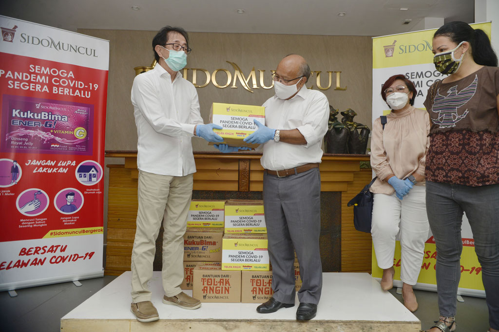 Direktur PT Sidomuncul Irwan Hidayat (kiri) menyerahkan secara simbolis kepada Presiden Direktur Metro TV Don Bosco Selamun bantuan paket sembako PT Sindo Muncul disaksikan Alissa Wahid (kedua kanan) dari Komunitas GUSDURian dan Melanie Subandono (kanan) dari Rumah Harapan, di Kantor PT Sidomuncul, Jakarta, Jumat, 17 April 2020.