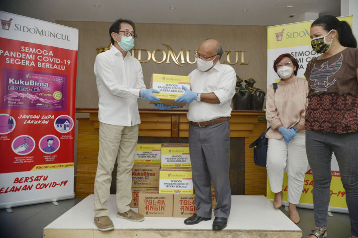 Direktur PT Sidomuncul Irwan Hidayat (kiri) menyerahkan secara simbolis kepada Presiden Direktur Metro TV Don Bosco Selamun bantuan paket sembako PT Sindo Muncul disaksikan Alissa Wahid (kedua kanan) dari Komunitas GUSDURian dan Melanie Subandono (kanan) dari Rumah Harapan, di Kantor PT Sidomuncul, Jakarta, Jumat, 17 April 2020.