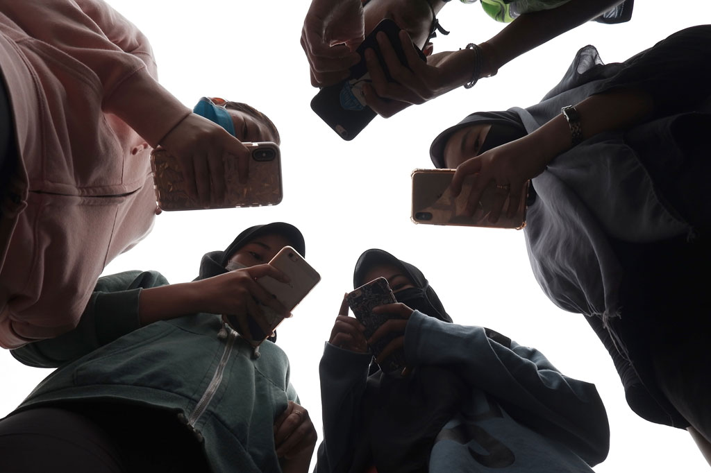 Sejumlah remaja tengah mengoperasikan ponsel mereka masing-masing di Medan, Sumatera Utara, Jumat, 17 April 2020.