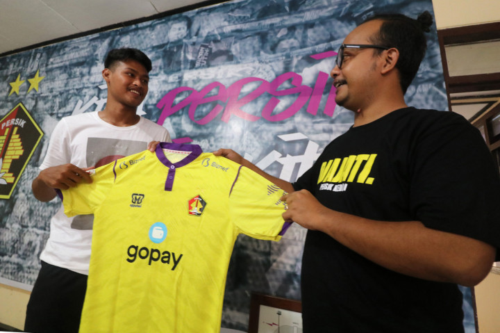 Pesepak bola Persik Kediri Septiap Bagaskara (kiri) menyerahkan jersey kepada pemenang lelang Reza Mardianto (kanan) di Kota Kediri, Jawa Timur. 
