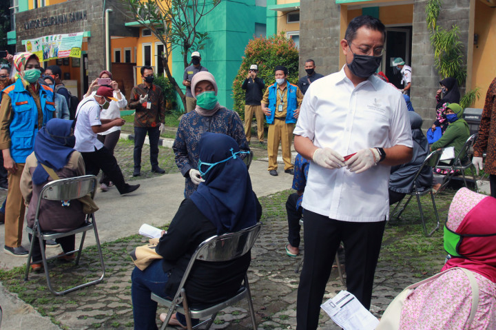 Menteri Sosial Juliari P Batubara (kedua kanan) didampingi Wali Kota Tangerang Selatan Airin Rachmy Diani (kiri berdiri) dan Sekertaris Dirjen Penanganan Fakir Miskin Nurul Farijati (kedua kiri berdiri) berbincang dengan warga penerima Kartu Keluarga Sejahtera di Ciputat, Tangerang Selatan, Banten.