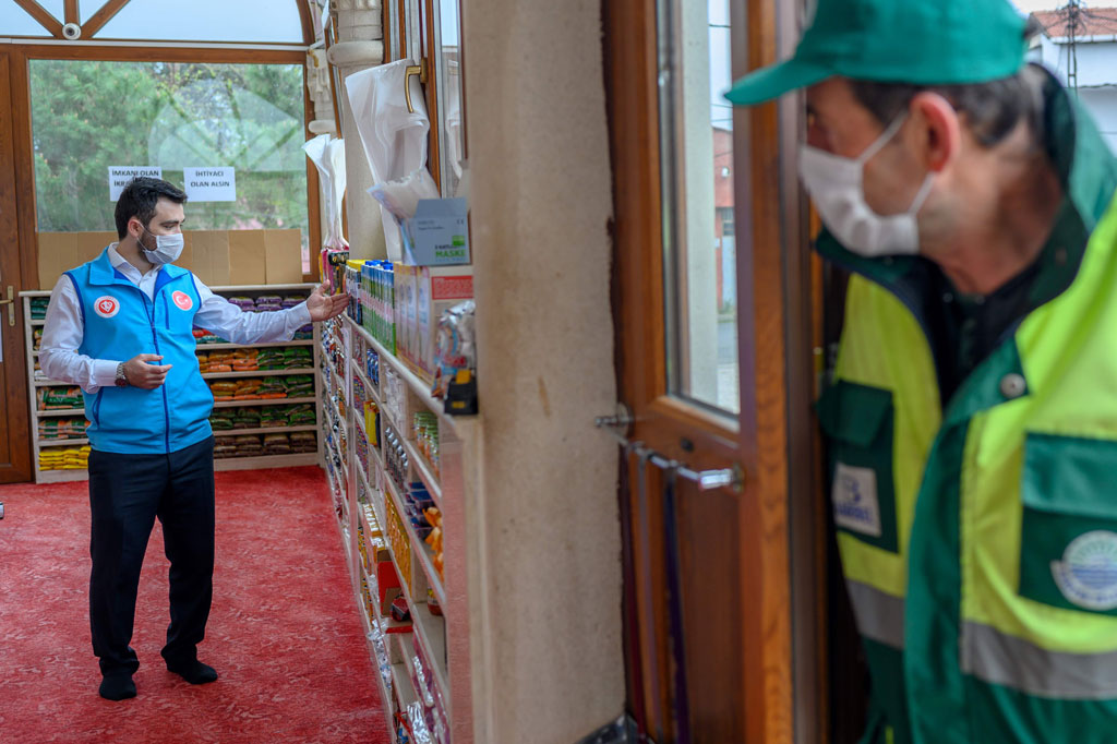 Abdulsamet Cakir, 33, imam Masjid Dedeman menyusun bahan-bahan sembako bantuan warga di rak pintu masuk masjid di Distrik Sariyer, Istanbul, Turki, Selasa, 21 April 2020.