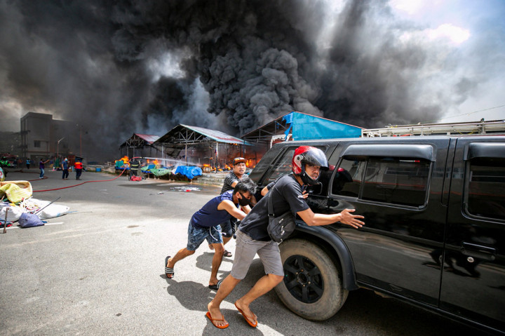 Warga berupaya menyelamatkan kendaraannya saat terjadi kebakaran di Pasar Second Taras, Batam, Kepulauan Riau.