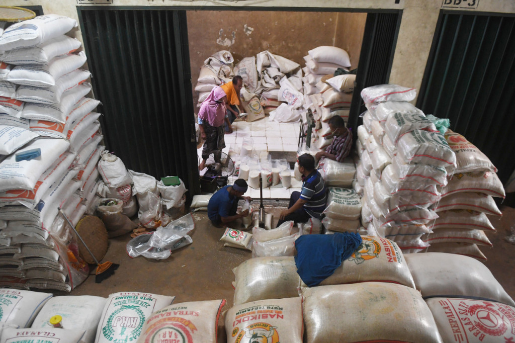 Pekerja mengemas beras ke dalam plastik di Pasar Induk Beras Cipinang, Jakarta, Senin, 27 April 2020.