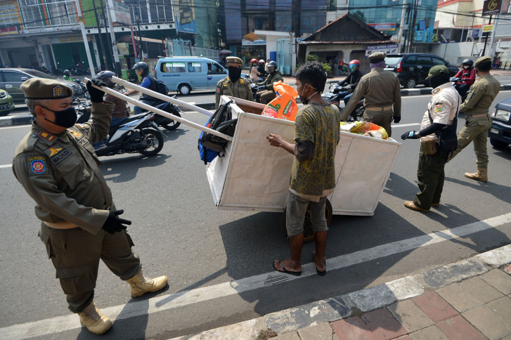 Sejumlah petugas Satpol PP mengamankan seorang penyandang masalah kesejahteraan sosial (PMKS) di Jalan Dewi Sartika, Cawang, Jakarta Timur.