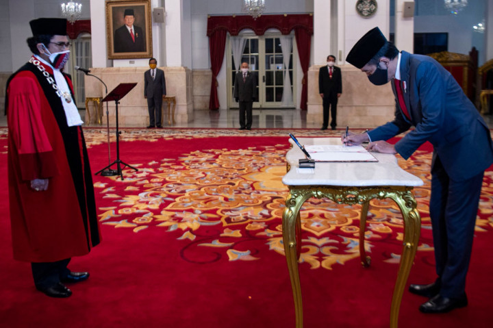 Presiden Joko Widodo (kanan) menandatangani berita acara pengucapan sumpah jabatan pelantikan Hakim Mahkamah Konstitusi (MK) Manahan Sitompul di Istana Negara, Jakarta. 