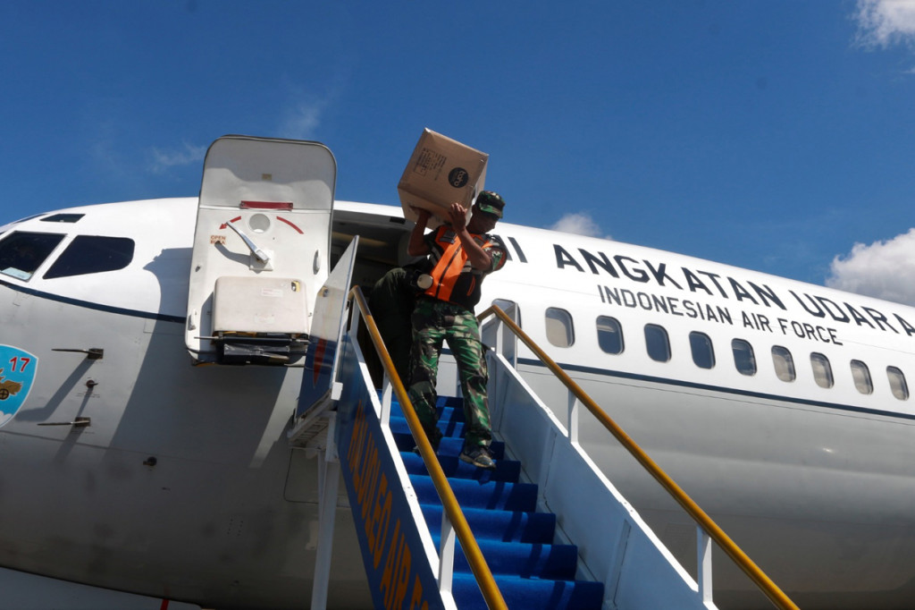 Prajurit TNI AU mengangkat kardus berisi alat pelindung diri (APD) dari dalam pesawat milik TNI AU setibanya di Bandara Haluoleo, Kendari, Sulawesi Tenggara.
