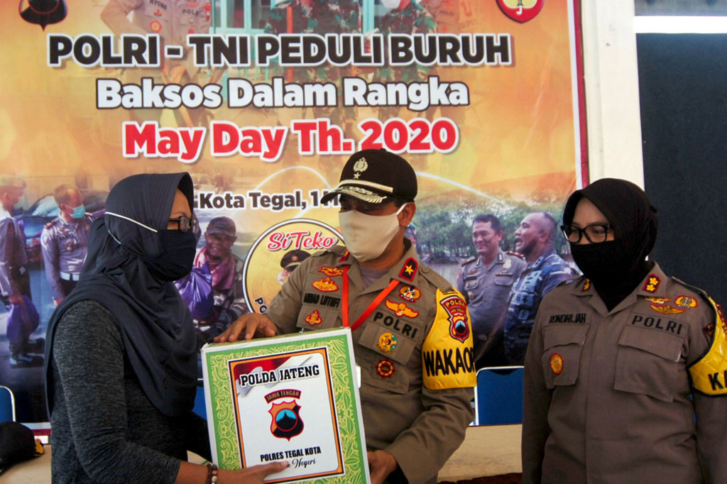 Wakapolda Jateng Brigjen Ahmad Luthfi (tengah) didampingi Kapolres Tegal Kota AKBP Siti Rondhijah (kanan) menyerahkan secara simbolis paket sembako kepada seorang buruh dari Konfederasi Serikat Pekerja Seluruh Indonesia (KSPSI) di Kecamatan Tegal Timur, Tegal, Jawa Tengah, Jumat, 1 Mei 2020.