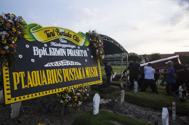 Keluarga dan kerabat mengusung peti dari jenazah musisi Erwin Prasetya saat proses pemakaman di TPU Keputih, Surabaya, Jawa Timur.