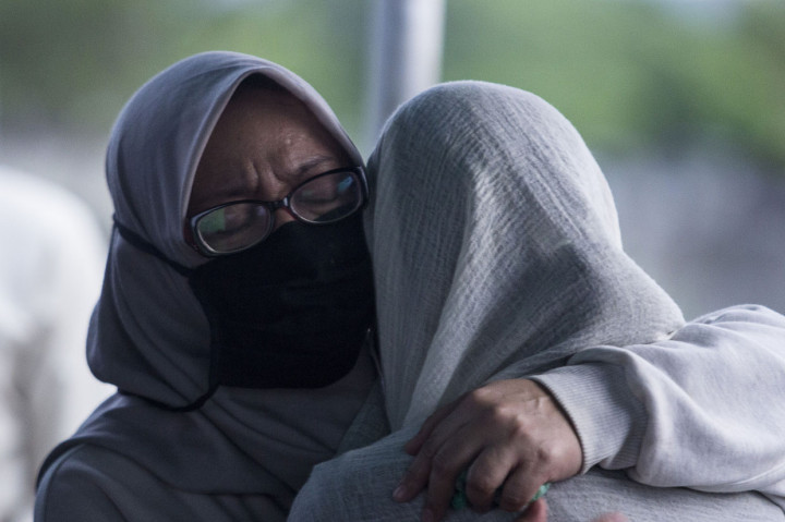 Istri mendiang musisi Erwin Prasetya, Miranda (kiri) memeluk salah satu putrinya saat proses pemakaman di TPU Keputih, Surabaya, Jawa Timur.
