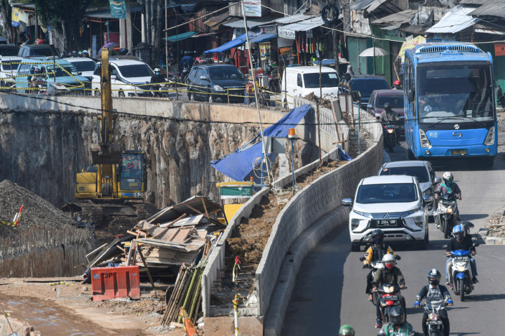 Sejumlah pengendara kendaraan melintas di samping proyek pembangunan Underpass Senen Extension di kawasan Senen, Jakarta.