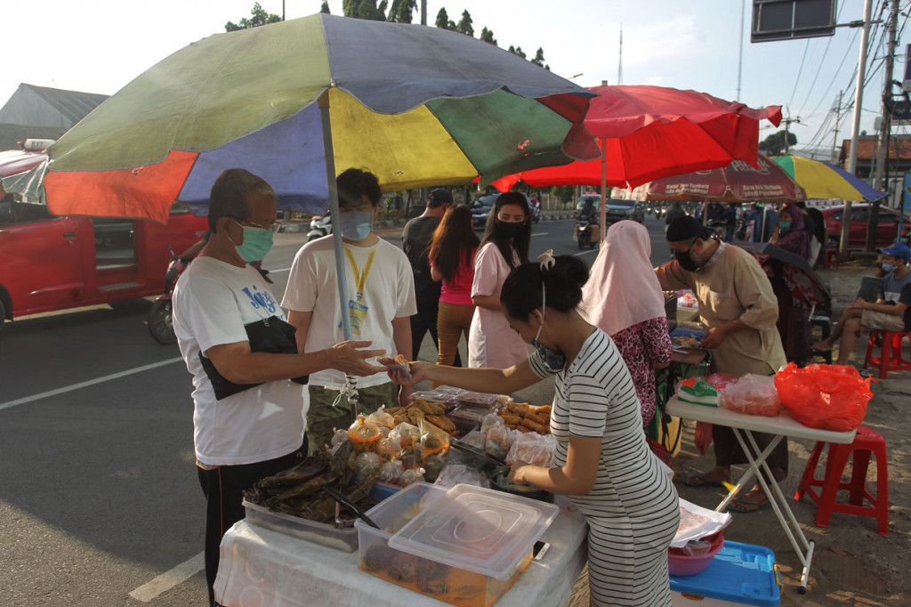 Pasar takjil dadakan yang menjajakan berbagai menu berbuka puasa ini masih berjualan meski dalam pemberlakuan Pembatasan Sosial Berskala Besar (PSBB) untuk mencegah penyebaran virus Korona.