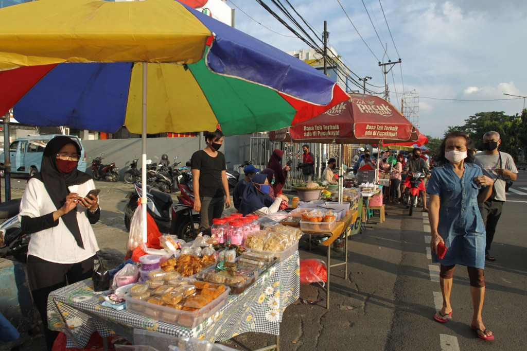 Para penjual takjil tersebut mengenakan masker sesuai dengan peraturan PSBB Jakarta.
