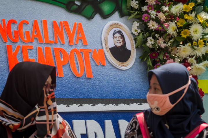 Pelayat melintas di depan karangan bunga duka cita almarhum Didi Kempot di rumah duka Sumber, Solo, Jawa Tengah.