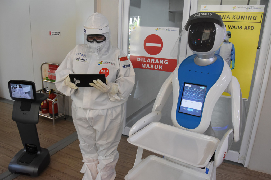 Petugas medis menjelaskan fungsi robot Amy (kanan) dan Temi (kiri) saat simulasi di Rumas Sakit Pertamina Jaya, Jakarta.