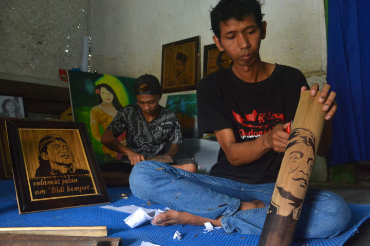 Anang Setyo Pambudi menyelesaikan ukiran pada bambu bergambar wajah almarhum Didi Kempot di Desa Sumberjo, Kabupaten Jombang, Jawa Timur, Rabu, 6 Mei 2020.