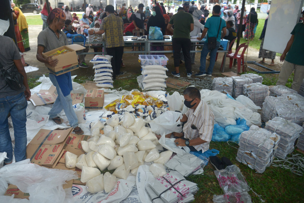 Warga antre membeli paket sembako murah yang digelar pemerintah Aceh Besar bekerja sama dengan Perom Bulog di desa Blang Bintang, Kabupaten Aceh Besar, Aceh.