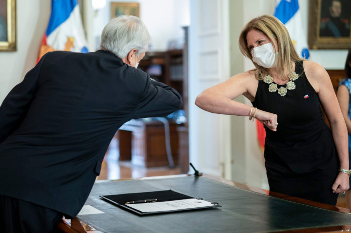 Presiden Chile Sebastian Pinera melakukan salam siku dengan menteri yang baru saja dia tunjuk, Macarena Santelices di Istana Presiden La Moneda, Santiago, Rabu, 6 Mei 2020 waktu setempat.