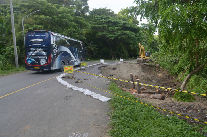 Bus umum antarprovinsi melintasi sisi jalan yang ambles di kawasan pegunungan Seulawah, Kabupaten Aceh Besar, Aceh, Kamis, 7 Mei 2020. 