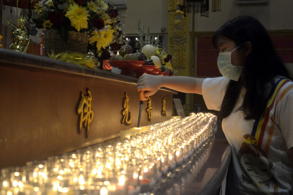 Umat Buddha menyalakan api pelita usai Kebaktian Detik-Detik Waisak yang diselenggarakan secara daring di Vihara Buddha Dharma, Kuta, Badung, Bali.