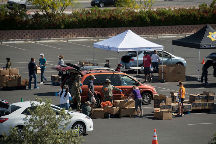 Lahan luas yang semula berisi deretan mobil, kini ditempati ratusan orang yang mengantre untuk menunggu giliran mengambil makanan. 