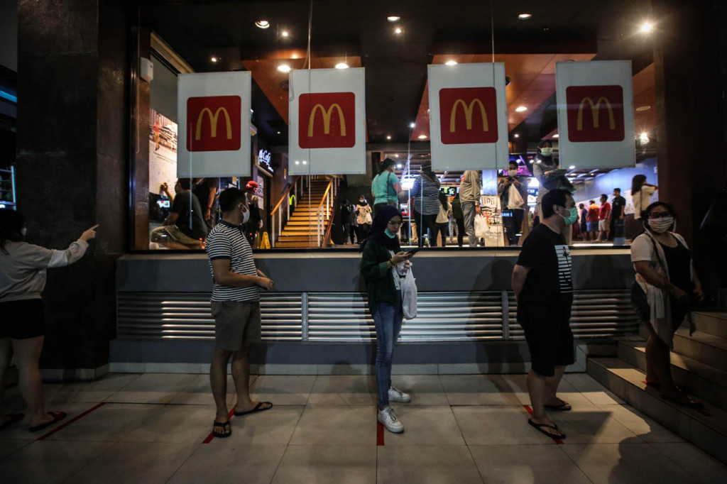 Petugas keamanaan mencoba mengatur para pengunjung ajar tetap menjaga jarak aman atau physical distancing.