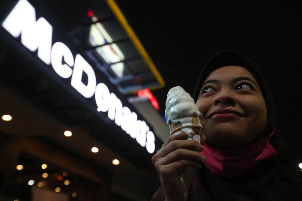 Pengunjung mengabadikan kenangan dengan memegang ice cream corn yang menjadi salah satu menu favorit di restoran cepat saji McDonald's gedung Sarinah, Jakarta Pusat.
