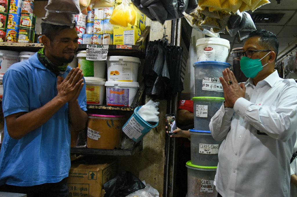 Direktur Utama Perum Bulog Budi Waseso berbincang dengan pedagang saat memantau kegiatan operasi pasar khusus gula di Pasar Jatinegara, Jakarta Timur, Jumat, 15 Mei 2020.