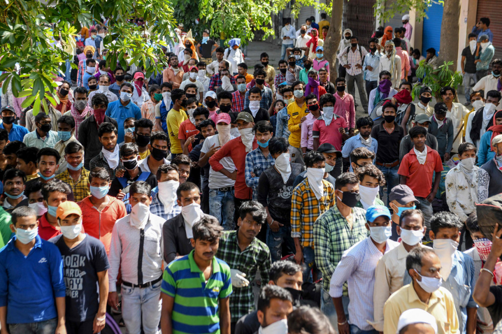 Pekerja migran dan keluarganya yang terdampar di stasiun kereta api menunggu pemeriksaan kesehatan sebelum naik kereta api ke Bhagalpur. AFP Photo/Narinder Nanu