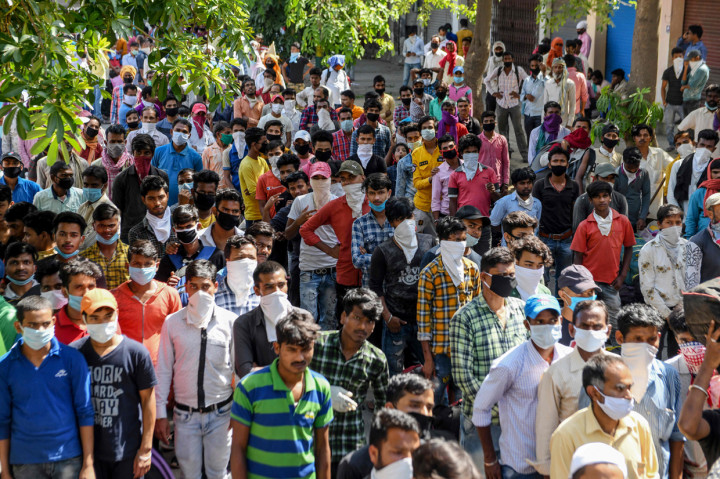 Pekerja migran dan keluarganya yang terdampar di stasiun kereta api menunggu pemeriksaan kesehatan sebelum naik kereta api ke Bhagalpur. AFP Photo/Narinder Nanu