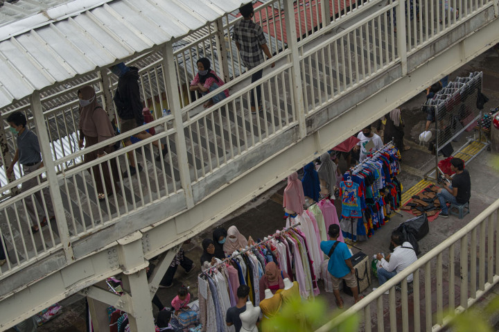 Warga berbelanja pakaian yang dijual pedagang kaki lima di atas trotoar Jalan Jati Baru Raya, Tanah Abang, Jakarta.