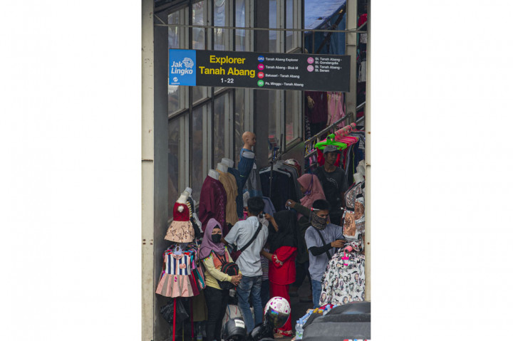 Warga berbelanja pakaian yang dijual pedagang kaki lima di salah satu halte bus di Jalan Jati Baru Raya, Tanah Abang, Jakarta.