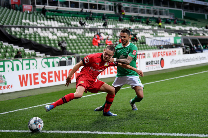 Pemain remaja Bayer Leverkusen Florian Wirtz (kiri) saling berebut bola dengan gelandang Werder Bremen Leonardo Bittencourt pada lanjutan pertandingan Liga Jerman di Bremen, Selasa, 19 Mei 2020 dini hari WIB.