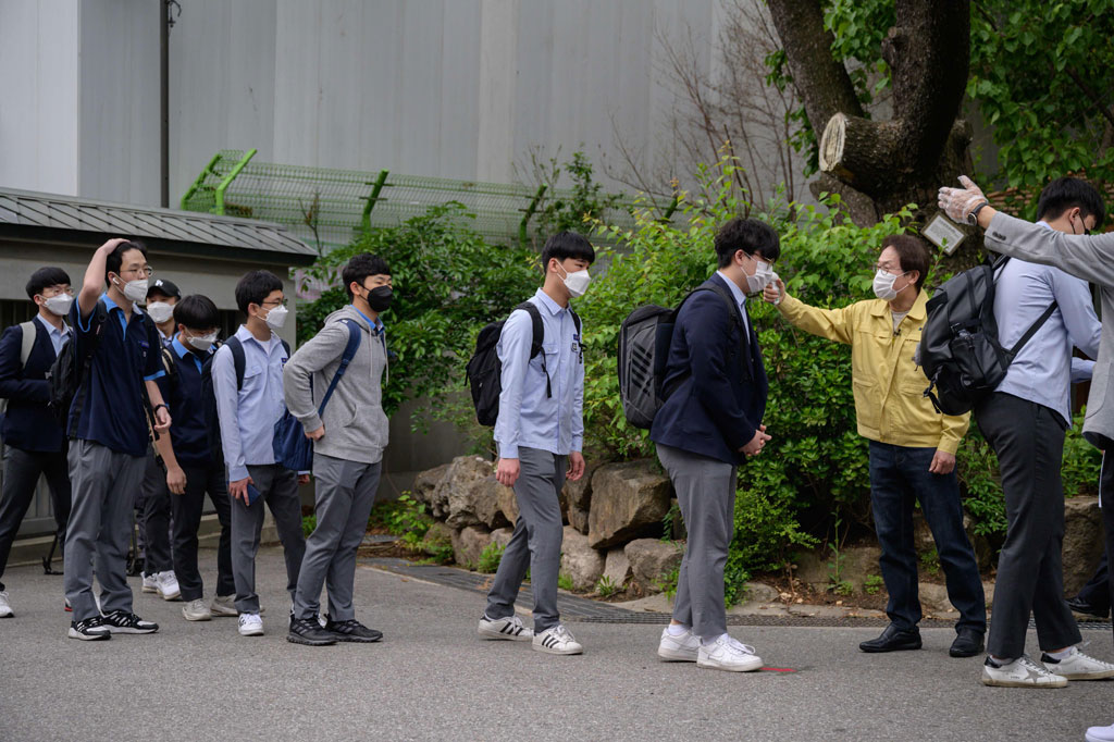Siswa sekolah di Korea Selatan memulai kegiatan belajar mengajar dengan tetap mematuhi protokol kesehatan. Di Keongbok High School, Seoul, Rabu pagi, para siswa berbaris untuk menjalani pemeriksaan suhu tubuh sebelum memasuki kelas masing-masing.