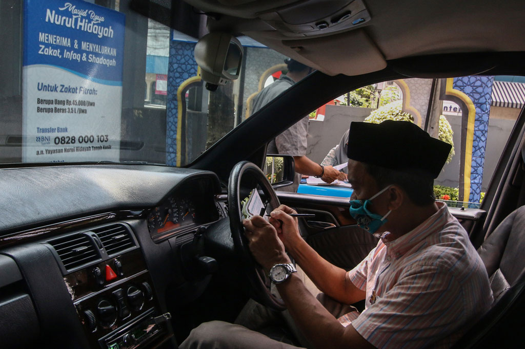 Warga membayar zakat fitrah di Masjid Raya Nurul Hidayah Tanah Kusir, Jakarta, dengan sistem drive thru, Rabu, 20 Mei 2020.