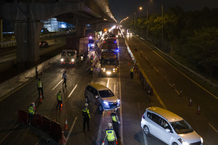 Petugas kepolisian mengarahkan kendaraan pribadi yang melintas di tol Jakarta-Cikampek untuk keluar melalui pintu tol Cikarang Barat 3, Jawa Barat, Kamis, 21 Mei 2020. Petugas gabungan memberlakukan penyekatan gelombang pemudik jelang perayaan Idul Fitri 1441 H dari arah Jakarta menuju Jawa Tengah.