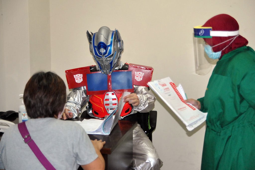 Seorang dokter spesialis menggunakan alat pelindung diri (APD) kostum superhero Optimus Prime saat memeriksa pasien yang berobat di Rumah Sakit Vania, Kota Bogor, Jawa Barat, Jumat, 22 Mei 2020.